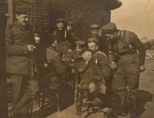Saxon infantrymen of RIR 241 share a cigarette with a Belgian boy